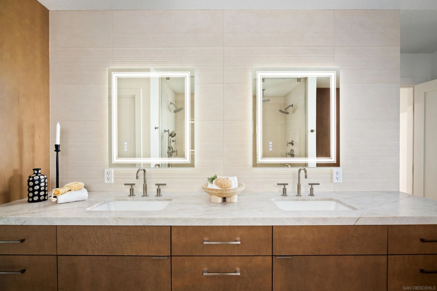 Double vanity bathroom with LED mirrors and wood cabinetry